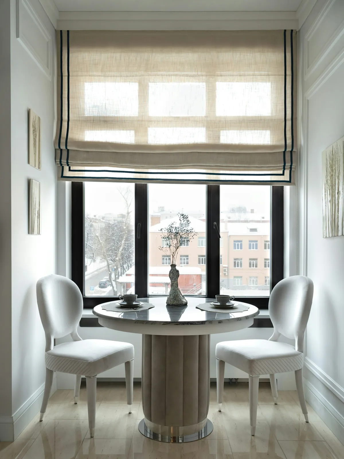 Breakfast nook with a white Roman shade over black-framed windows