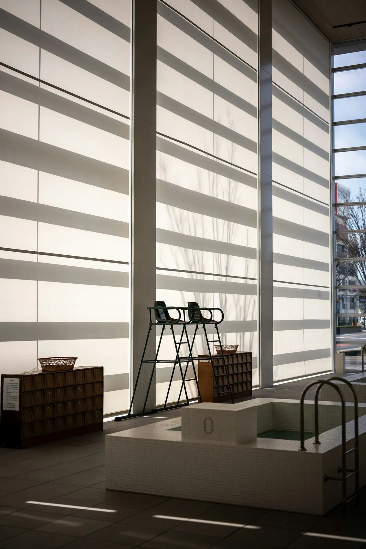 Banded sheer shades on tall windows in a dim room