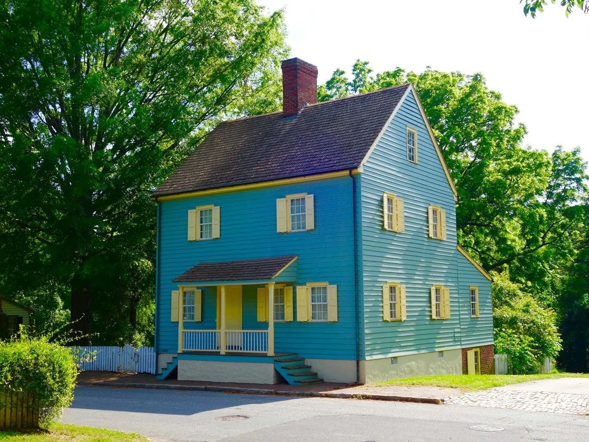 Blue clapboard colonial house with yellow shutters