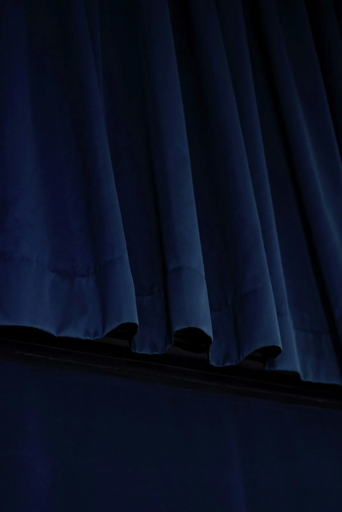 Deep blue velvet drapery hanging in soft folds