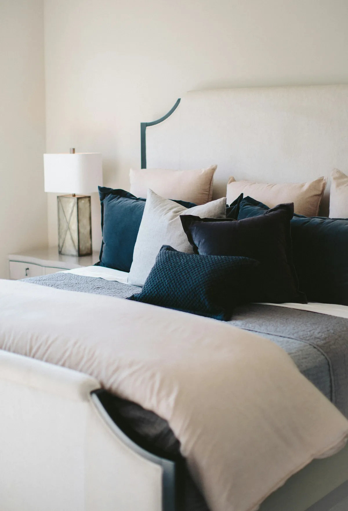 Bed with a white duvet and navy and white pillows