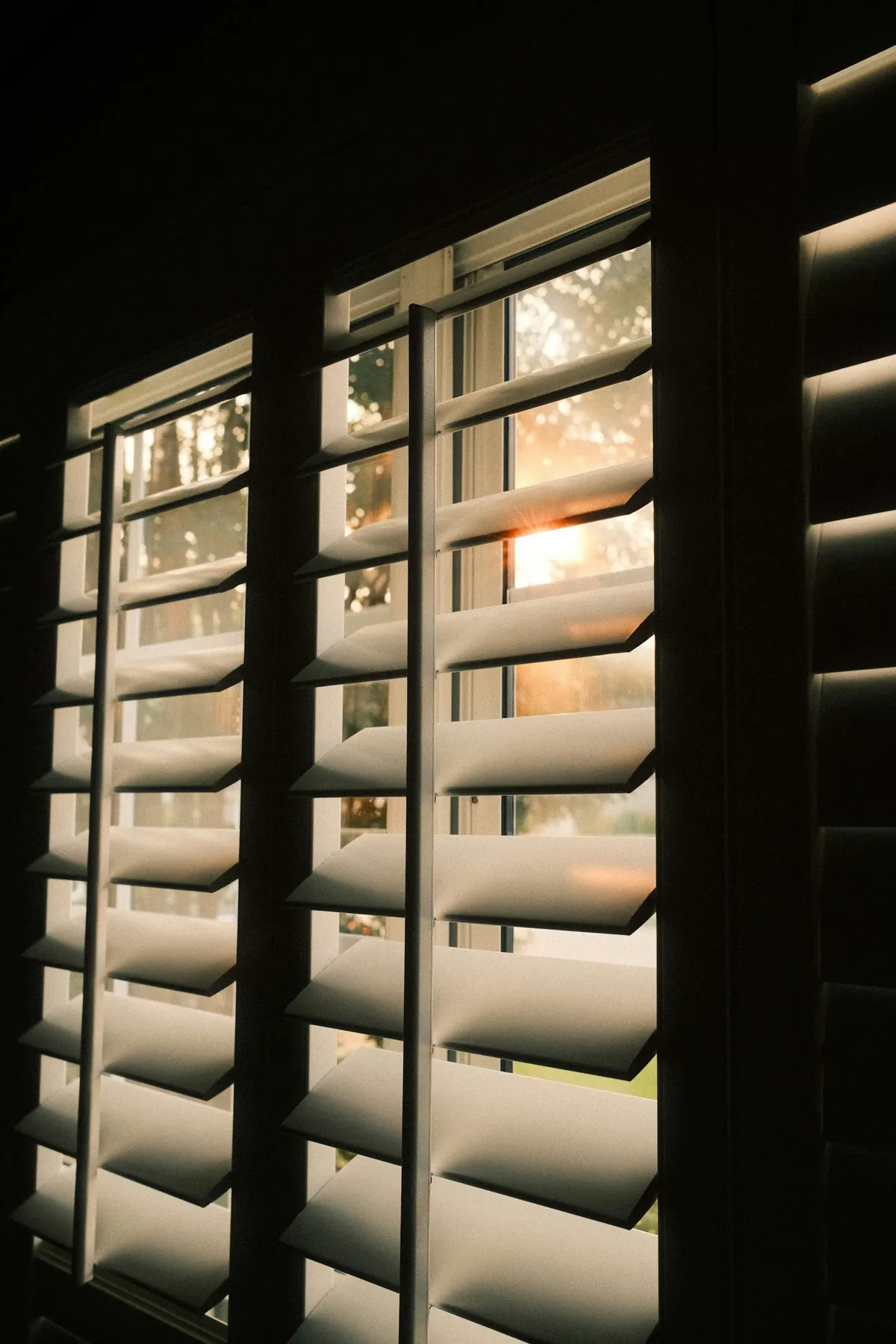 Dark wood shutters with light through the louvres