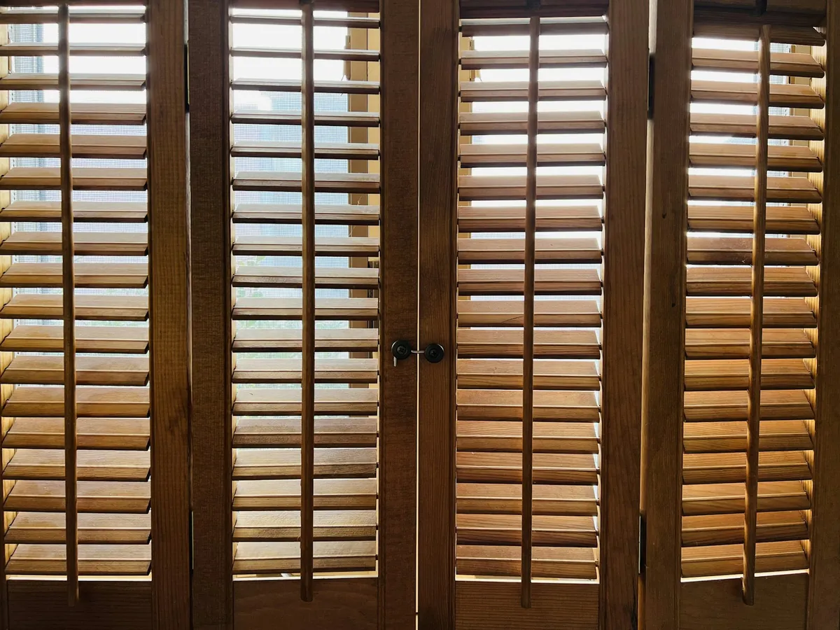 Wooden plantation shutters with the louvres half open