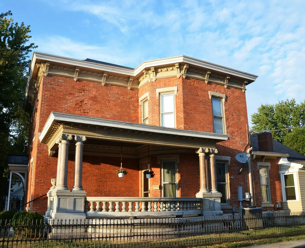 Red brick Italianate house with a covered front porch