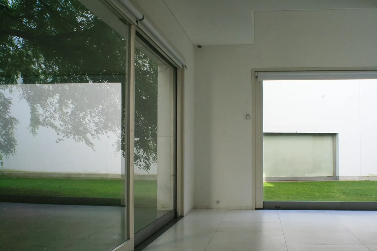 Wide sliding glass doors with no window covering, opening to a lawn