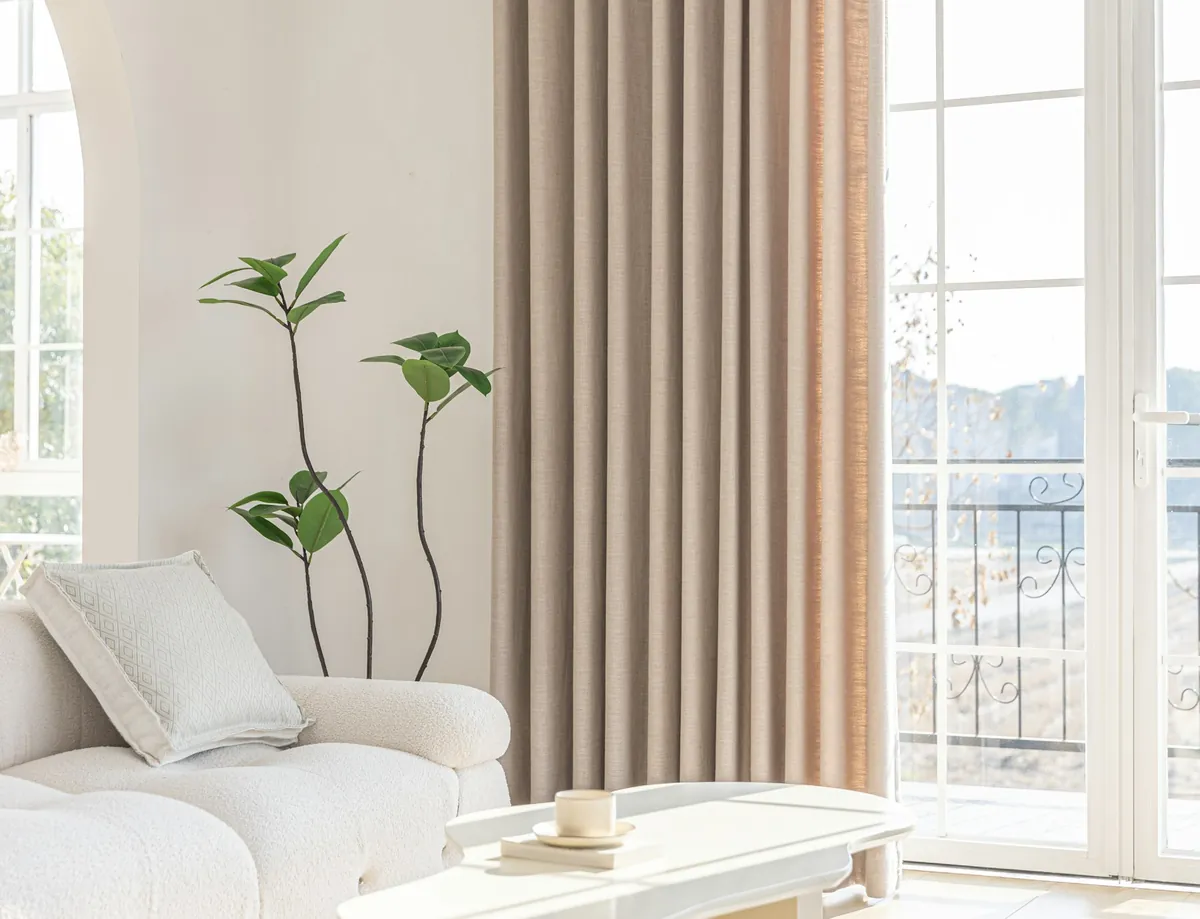Floor-length beige drapery beside French doors in a white living room