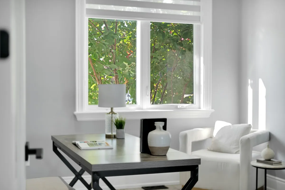 Bright home office with a desk beneath a white-framed window